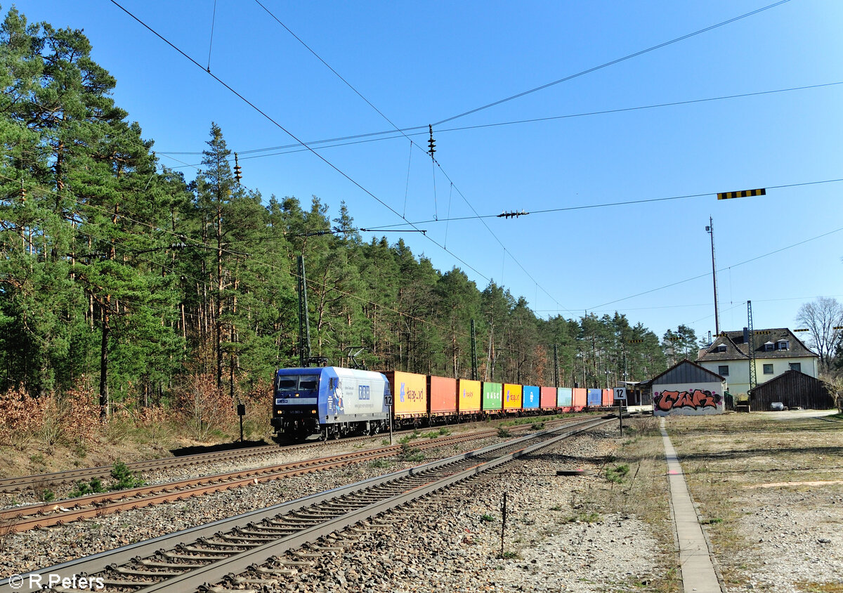 145 063 mit einem Containerzug aus Regensburg Ost bei der Durchfahrt in Ochenbruck. 09.03.24