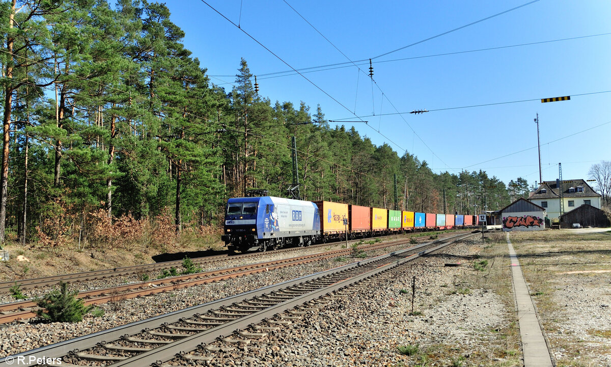 145 063 mit einem Containerzug aus Regensburg Ost bei der Durchfahrt in Ochenbruck. 09.03.24