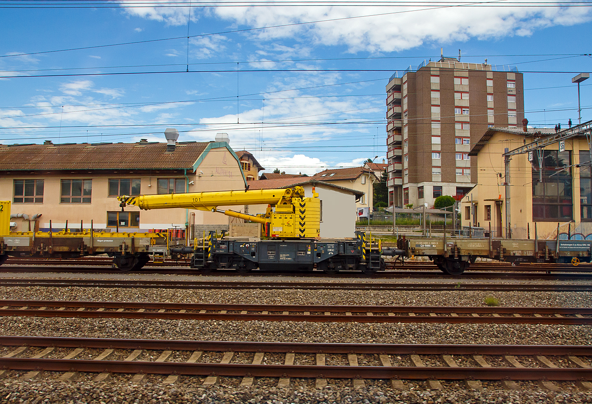 Der SBB 10 t-Gleisbauschienenkran Kirow Multi Tasker 100 Xtmass 99 85 92 19 006-5 CH-SCCI und links der zweiachsige Schutzwagen Xs 40 85 95 56 492-8 CH-SBBI, sowie der zweiachsige Schutzwagen Xs 40 85 95 56 492-8 CH-SBBI, stehen am 21.05.2018 in Lausanne (aufgenommen aus einem fahrenden Zug). 

Der Kran wurde 2007 von Kirow in Leipzig unter der Fabriknummer 138506 gebaut und an die SBB Infrastruktur geliefert.

Die Schweizerischen Bundesbahnen haben die größte Verkehrsleistung pro Einwohner sowie die höchste Zugdichte der Welt. So ein dichtes Bahnnetz will unterhalten und gepflegt werden und das bei einem Minimum von Sperrzeiten, um die täglich 967.000 Fahrgäste der SBB rechtzeitig an ihr Ziel zu bringen. Dafür bestellte die SBB zwölf dieser  Multi Tasker der 100er Reihe, die im Zeitraum von Dezember 2006 bis Oktober 2007 an die SBB CFF FFS geliefert wurden.

Als kleinste Kirow Baureihe kann der Multi Tasker 100 vor allem aufgrund seiner kompakten Erscheinung überzeugen. Sein festes Gegengewicht und der so geringgehaltene Heckradius ermöglichen dem Multi Tasker 100 die Profilfreiheit bei der Erfüllung seiner Aufgabe, der restliche Schienenverkehr bleibt ungestört. Dank der schnellen Arbeitsweise des Krans sind die erforderlichen Sperrzeiten während der Einsätze minimal. Der Multi Tasker 100 ist ideal geeignet für leichtere Montagetätigkeiten wie das Setzen von Masten, Schallschutzelementen usw. Anschlagmittel für Sonderanwendungen können als Zubehör mitgeliefert werden

TECHNISCHE DATEN:
Spurweite: 1.435 mm 
Achsanzahl: 4
Länge über Puffer 10.000 mm
Drehzapfenabstand: 6.000 mm
Achsabstand im Drehgestell: 1.600 mm
Maximale Tragfähigkeit: 10 t
Höchstgeschwindigkeit: 35 km/h (eigen) /120 km/h (geschleppt)
Eigengewicht: 70.000 kg
Achslast Transportstellung: 18 t 
Abstützbreite: 2,6 bis 4,6 m
Arbeitsradius: 18,5 m
Maximale Ausladung vor Puffer: 13,5 m
Maximale Hakenhöhe: 17,5 m
Kleinster befahrbarer Gleisbogen: R=80 m
Bremse: KE-GP mZ