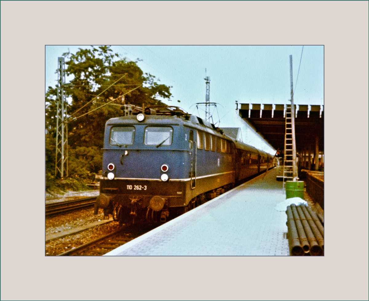 Die DB 110 262-5 mit dem D 358 von Berlin nach Basel SBB, welcher auch einen direkten Schlafwagen aus Moskau führt beim Halt in Basel Bad. Bf. 
Das neue Bahnsteigdach ist im Moment der Aufnahme noch im Bau. 

30. Juli 1982