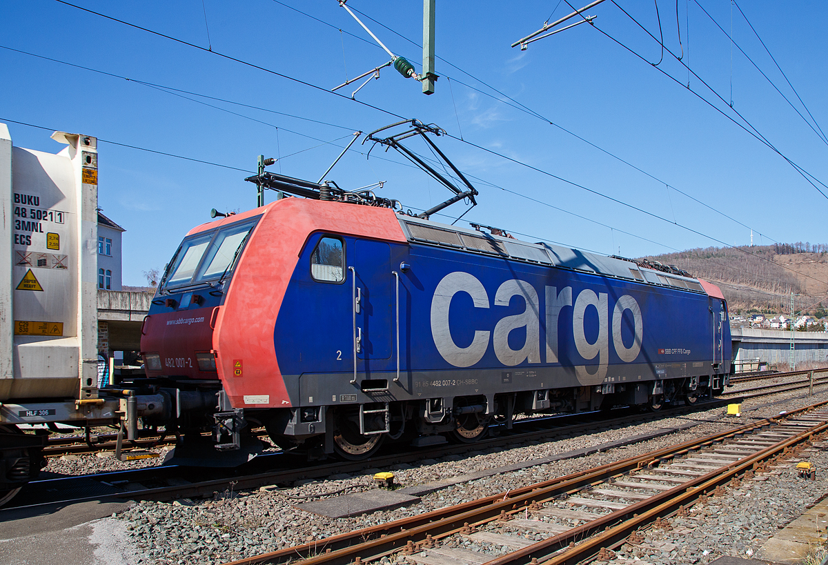 Die Re 482 007-2 (91 85 4482 007-2 CH-SBBC) der SBB Cargo AG zieht am 24.03.2021 einem HUPAC-KLV/Container-Zug durch Niederschelden in Richtung Siegen, hier hat sie gerade den Bü 343 (Km 112,183 der Siegstrecke KBS 460) passiert. 

Die TRAXX F140 AC1 wurde 2002 von Bombardier in Kassel unter der Fabriknummer 33474 gebaut und an die SBB Cargo AG geliefert. Sie hat die Zulassungen und Zugbeeinflussungssysteme für die Schweiz und Deutschland. Zurzeit ist sie an die SBB Cargo International AG vermietet.