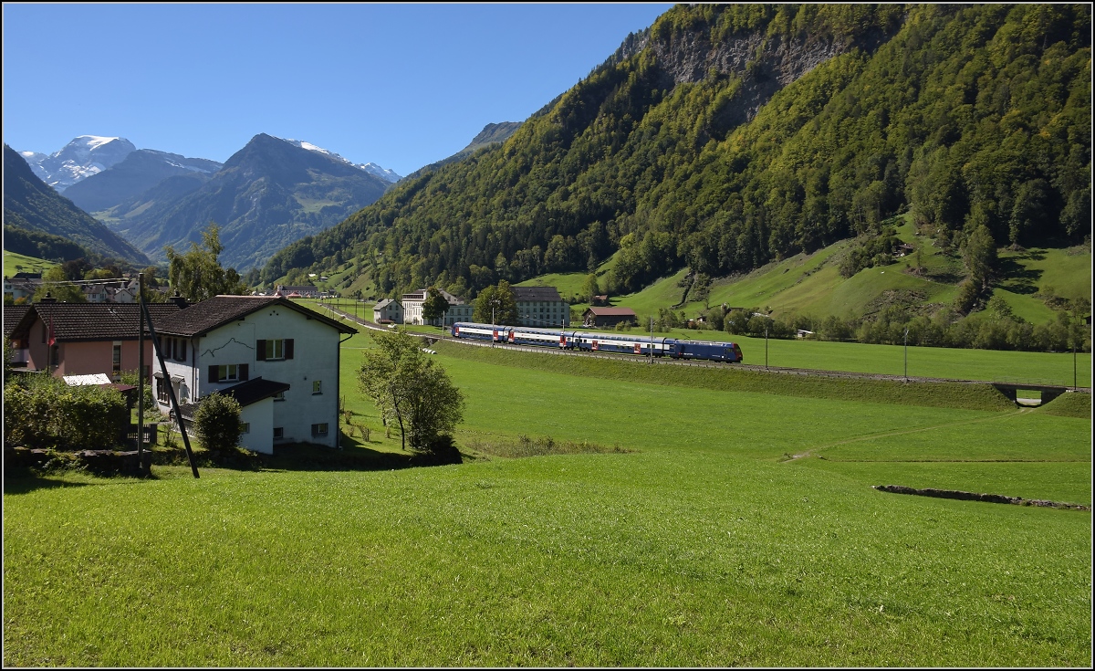 Im tiefeingeschnittenen Tal der Linth zeigt sich ein unbekannter Zug der S-Bahn Z�rich mit Re 450 in ganz besonderem Licht. Im Hintergrund erhebt sich der T�di, h�chster Alpengipfel zwischen den Viertausendern von Berner Oberland und Berninamassiv. Diesbach, September 2019.