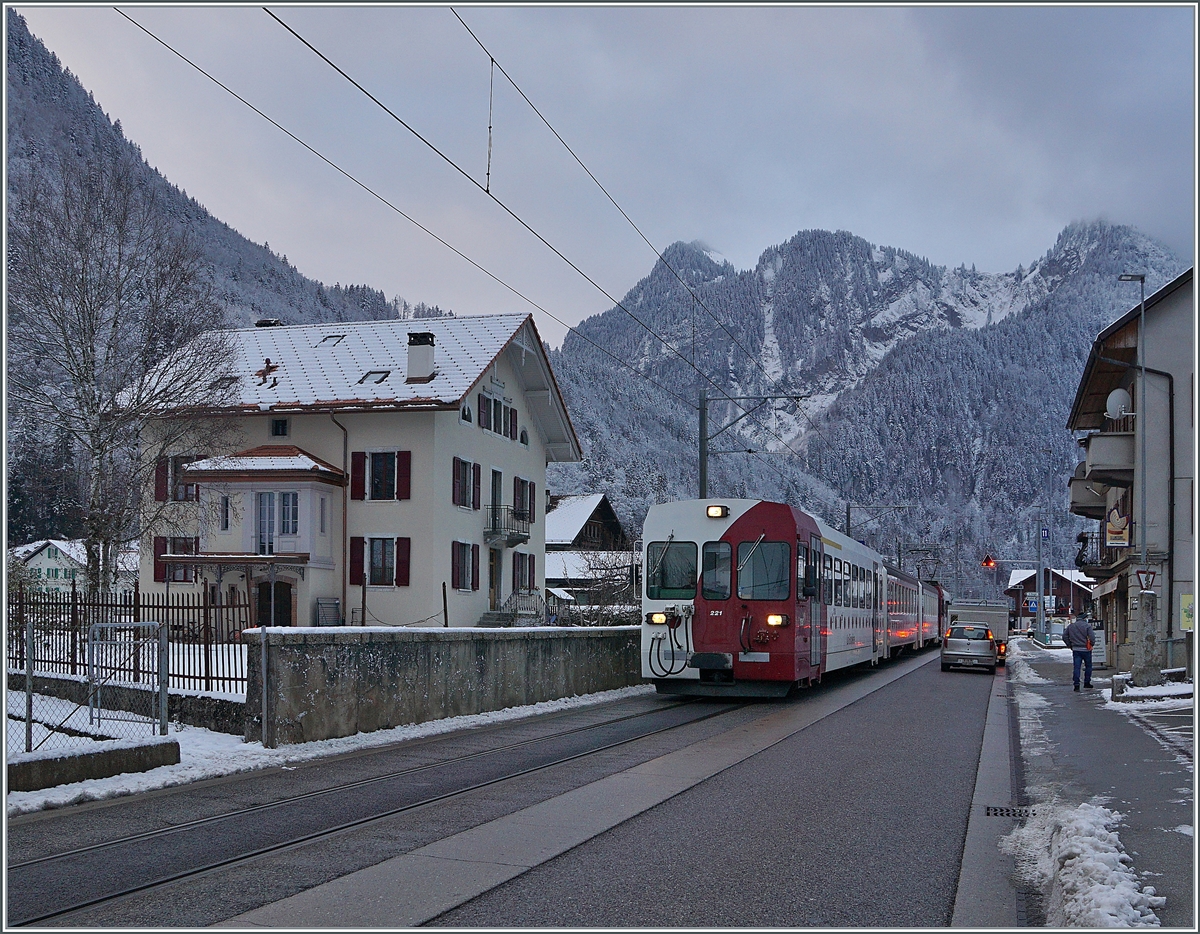 Mit dem Bt 221 an der Spitze verlässt ein TPF Regionalzug nach Bulle Montbovon, wo wie hier zu sehen die Strecke einigen hundert Meter auf der Strasse verläuft. 

3. Dez. 2020