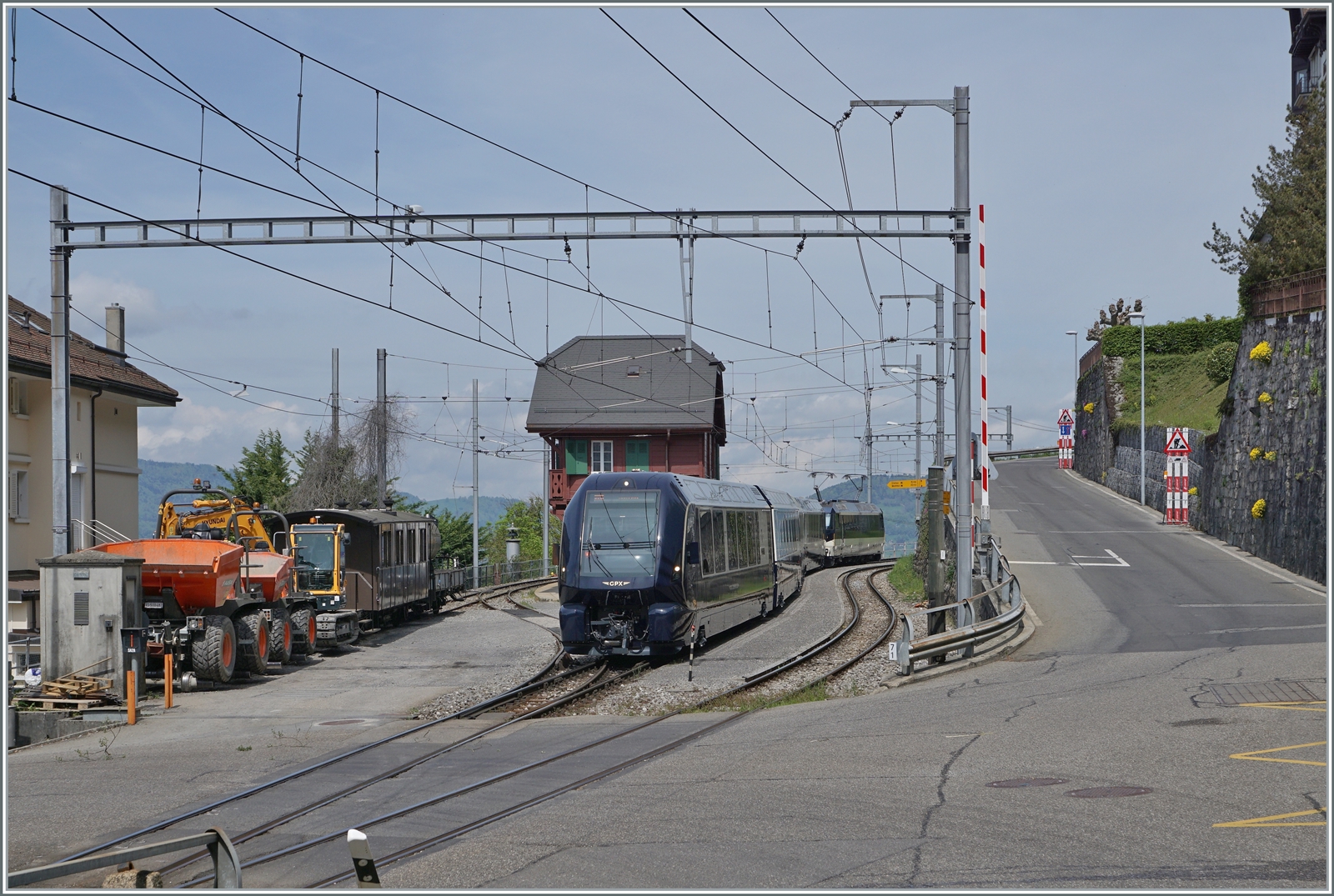 Der MOB GPX 4065 von Zweisimmen nach Montreux mit der schiebenden Ge 4/4 8004 muss in Chamby den Gegenzug abwarten. Obwohl der Zug infolge Problemen mit Normalspurweichen nur noch bis und ab Zweisimmen verkehrt, kommt er dank der Blonay-Chamby Bahn weiterhin in Sichtt-Kontakt mit der BOB, wie der links im Bild zu erkenne BOB Kaiserwagen. Das Bild entstand beim geöffneten Bahnübergang, siehe Barriere rechts im Bild. 

6. Mai 2023
