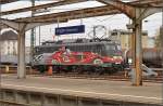 Die exotische 115 509-2 mit der Autozugwerbung in Diensten der Gäubahn-ICs wartet in Singen auf den nächsten Einsatz.