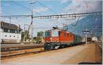 Die SBB Re 4/4 II 11187 verlässt mit einen Schnellzug den Bahnhof von Martigny.